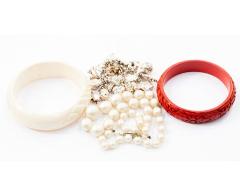 A silver charm bracelet, costume pearl necklace, ivory bangle and lacquer bangle (4)