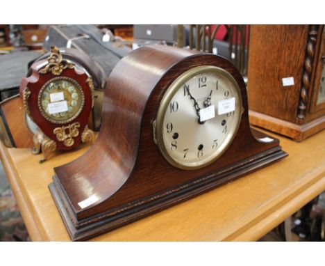 A 1920's oak Napoleon shaped eight day mantle clock, with Arabic numerals on a silvered dial, having a Westminster chime, the