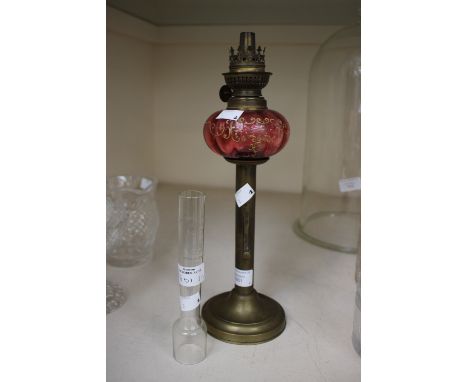 A French oil lamp, the base a converted early 19th Century push up candlestick with the oil lamp, cranberry glass and gilt en