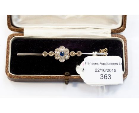 An Edwardian diamond and sapphire bar brooch, central flower with millegrain set sapphire surrounded by six old cut diamonds 