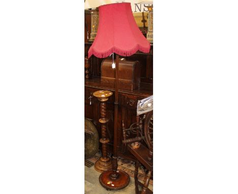 A Georgian style mahogany standard lamp fitted with fuschia pink shade, on a turned and reeded column.