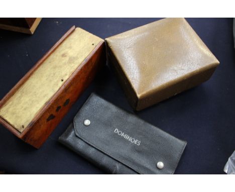 A box of ebony and bone dominoes, a pouch of dominoes set and an early 20th Century bridge playing set. (3)