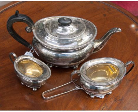 A George V silver three piece tea service, comprising teapot, milk jug and sugar bowl, all raised on bun feet, Sheffield 1919