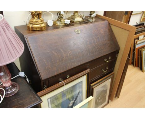 A George III oak bureau, the fall front enclosing a fitted interior of drawers and pigeon holes, the central drawer inscribed