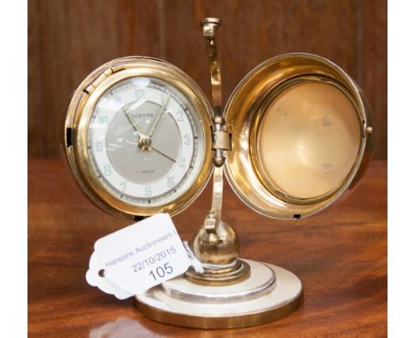 A 1940s Art Deco brass and silver plated travelling alarm clock, with a 17 jewel movement, raised on a stepped base 