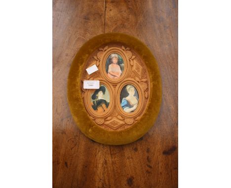 A velvet oval picture frame, being heavily carved in centre, having three oval portrait holders.