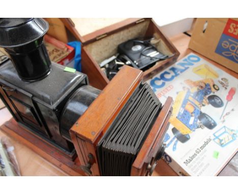 A vintage Magic lantern projector with wooden base, metal body and bellows unit to the front, an Aldin Universal projector in