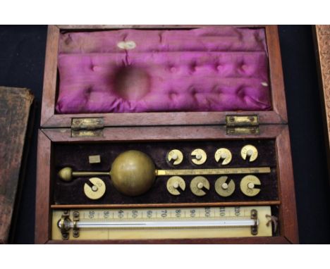 A 19th Century Sikes hydrometer fitted in a mahogany box, complete with tables book. (2)