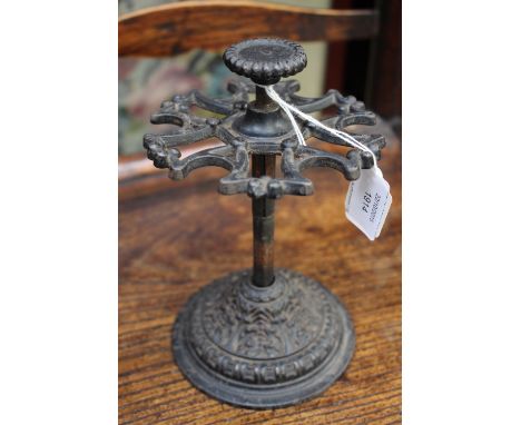 An early 20th Century cast iron stamp stand with revolving detail, could double as decorative pipe rack.