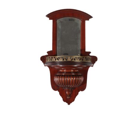 A Mahogany Wall Bracket, late 19th century, the moulded pediment above a bevelled glass plate, the shelf with a pierced brass