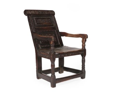 A 17th Century Joined Oak Wainscot Armchair, dated 1675 and initialled LW, the carved top rail above a back support with two 