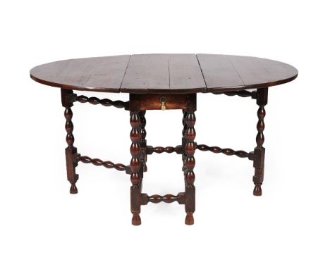 An Early 18th Century Joined Oak Six-Seater Gateleg Dining Table, with oval drop leaves above a single drawer, on bobbin turn