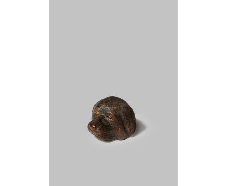 A JAPANESE WOOD NETSUKE MEIJI 1868-1912 Carved as a dog's head, the eyes inlaid with horn and with darker pupils, the hair fi