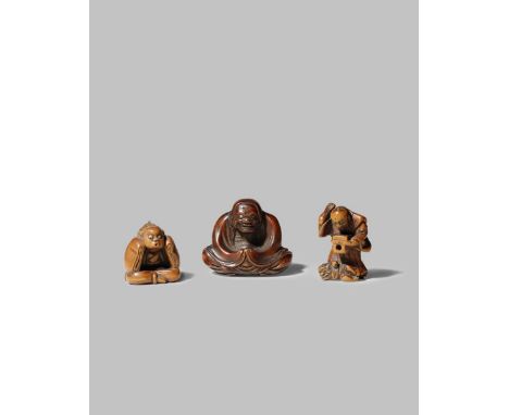 THREE JAPANESE WOOD NETSUKE MEIJI 1868-1912 One depicting a seated Daruma, another a man throwing beans at an oni on Setsubun