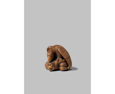 A FINE JAPANESE WOOD NETSUKE EDO/MEIJI PERIOD Depicting an eagle attacking a monkey, the raptor holding its terrified prey in