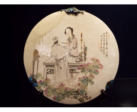 A 19thC Chinese circular porcelain wall plaque having an interior scene with male and female figures and blossom tree, the me