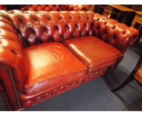 A Victorian style Ox blood red leather button-back Chesterfield two seater sofa 