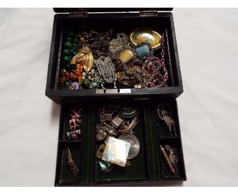 A two tier jewellery box containing a quantity of costume jewellery to include brooches, enamelled earrings, silver items, Al