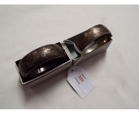 Two vintage hinged silver bangles with foliate scroll engraved decoration  One in good condition, no dents or splits. Other h