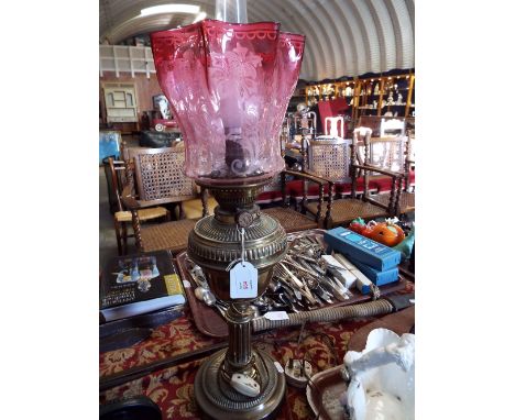 A Victorian brass oil lamp converted to electricity with cranberry acid etched fluted glass shade   Shade is in good conditio