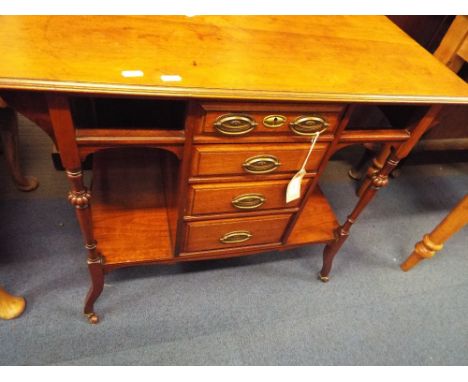 An Edwardian walnut side cabinet the moulded top over four central short drawers with pressed brass swing handles flanked by 