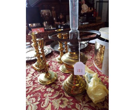 Two pairs of brass candlesticks and a brass oil lamp