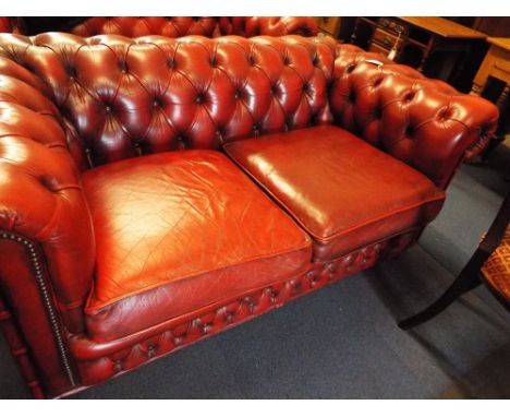 A Victorian style Ox blood red leather button-back Chesterfield two seater sofa 