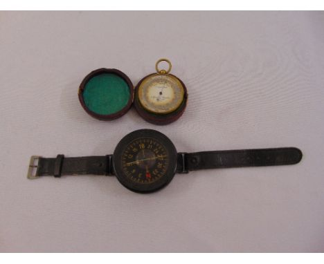 A Negretti and Zambra pocket barometer/altimeter in fitted leather case and WWII German compass mounted on a wrist strap