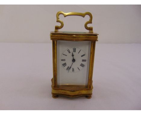 A French brass carriage clock with white enamel dial, roman numerals, to include key