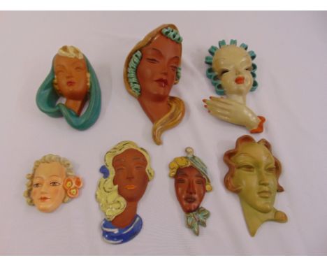 Seven polychromatic Art Deco style ceramic wall plaques in the form of ladies heads
