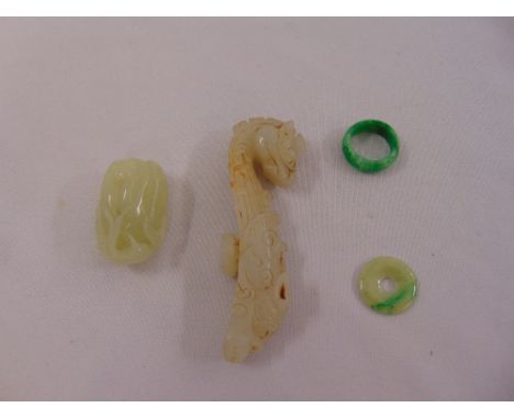 A quantity of jade to include an Archers ring, a knife rest, a pierced disc and a carving of a gourd