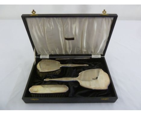 A cased four piece engine turned silver dressing table set comprising mirror, comb and hair brush