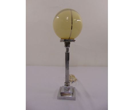 An Art Deco table lamp in the form of a chrome plated Corinthian column with globular glass shade