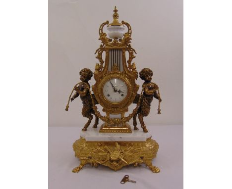 An Imperial style gilt metal and marble mantle clock, enamel dial, two train movement with putti figurines to the sides and m