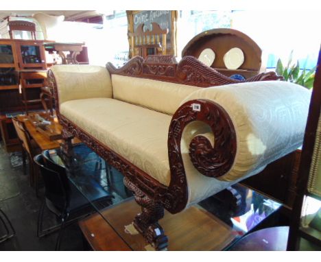 A three seater, cream upholstered, scroll end carved sofa