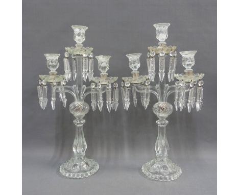 A pair of moulded glass candelabra, the scalloped drip trays with hanging lustres, 52cm high (2) 