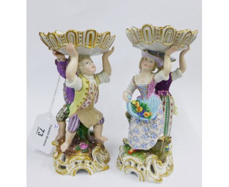 A pair of 19th century Meissen porcelain table salts, the rococo style oval bowls supported by two standing figures, on a flo