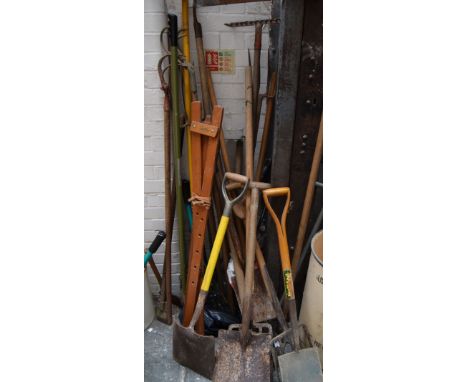 A large quantity of garden tools, including rakes, spades, hoes and trowels, with makes including Spear & Jackson