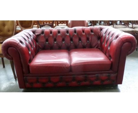 A red leatherette Chesterfield two seater sofa