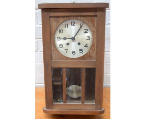 A vintage teak wall clock with pendulum and key