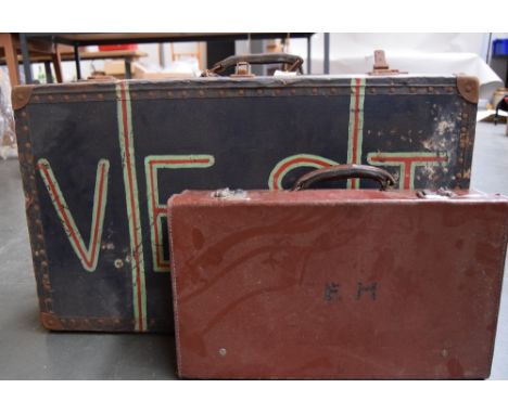 A large vintage luggage trunk with handle, wooden banding and metal studs, painted with the word 'VEST' and the interior divi