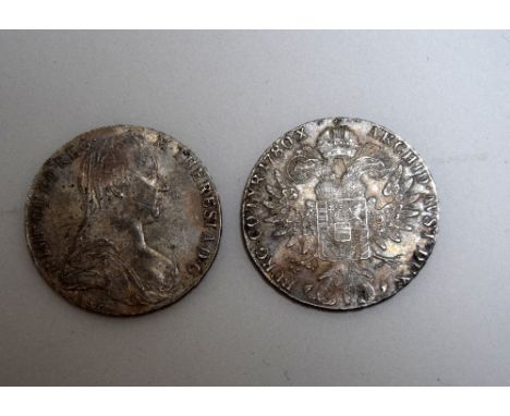 A pair of silver Austrian thalers, dating from 1780 and bearing the head of Empress Maria Theresia of Habsburg on the obverse