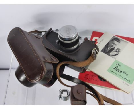 A Vintage Leica (Ernst Leitz Wetzler) Camera, no. 764804 dd 1965 with the original Leica camera guide.