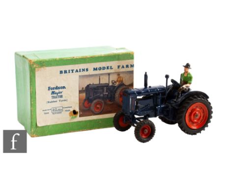 A Britains Farm Series 128F Fordson Major Tractor with dark blue body, orange wheels and black rubber tyres, with driver, in 