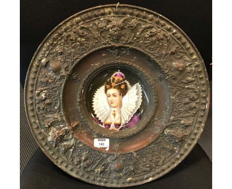 A Continental embossed metal alms-type dish marked 'Bene factum', inset with a portrait dish depicting a bejewelled lady, ove