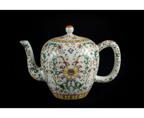 Chinese Art. A famille rose porcelain teapot decorated with flowers and sprays and bearing a six character Qianlong zhuanshu 