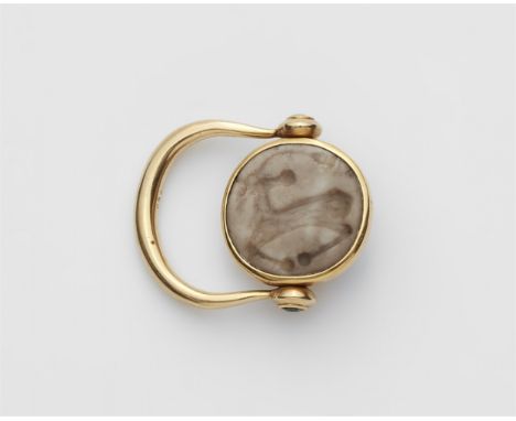 18 kt Gelbgold. Omega-förmige Klappschiene, die Scharniere gefasst mit kleinen Demantoiden. Drehbarer Ringkopf gefasst mit bo