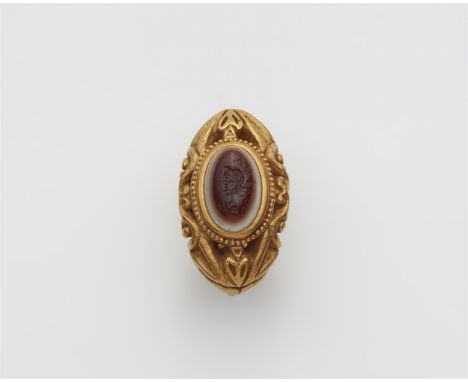 22 kt Gelbgold. Massive durchbrochene Gussschiene mit historisierendem Relief. Gefasst mit einem braun-weißem Lagenachat (14,