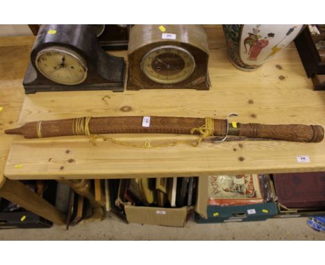 A carved wooden Eastern sword and scabbard 