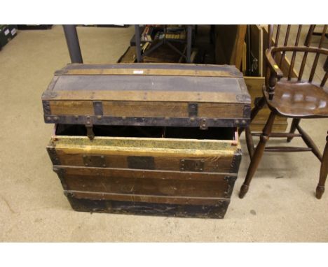 A wooden bound dome topped travelling trunk